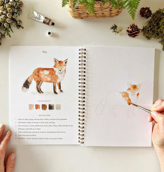 A model paints a fox in the Woodland Watercolor Workbook