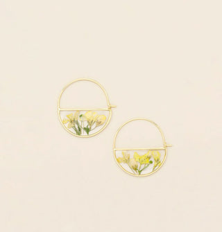 Gold hoop earrings with bottom semicircles containing resin-encased pressed yellow flowers and green stems and leaves