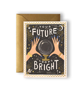 Greeting card with metallic gold envelope underneath features crystal ball and hands design and says, "Your future looks bright" in white lettering